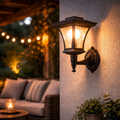 Schwarze LED-solar wandlampe retro aus schmiedeeisen mit warm leuchtendem glas außenwandleuchte