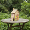 Ein charmantes vogelhaus aus holz mit schrägem dach und bunten chip und chap illustrations an den seiten