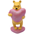 Gelbe winnie puuh dekofigur aus kunststoff mit glitzerndem rosa herz-kissen zum dekorieren