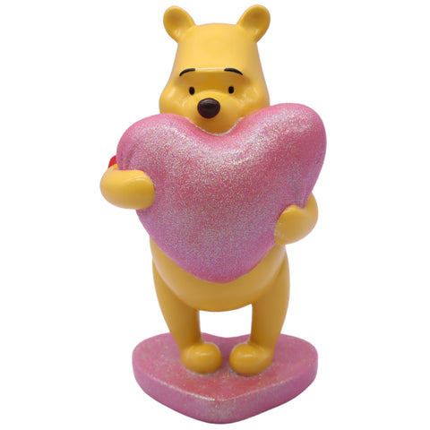 Gelbe winnie puuh dekofigur aus kunststoff mit glitzerndem rosa herz-kissen zum dekorieren