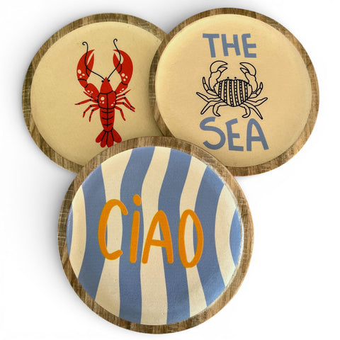 Set aus drei runden keramikuntersetzern mit holzrand dekoration mit rotem lobster blauem krabbenmotiv und ciao text
