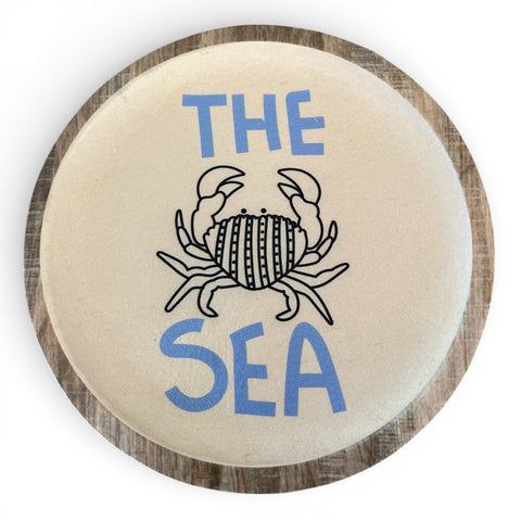 Creamfarbene keramikwandplatte 19,5 cm mit schwarzem krabbenmotiv und blauem schriftzug the sea