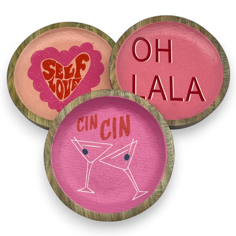 Set aus drei runden holzuntersetzern mit rosa und pfirsichfarbenen flächen und unterschiedlichen designs text und herz