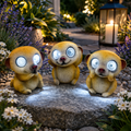 Solarlampe led erdmännchen mit drei goldgelben harzfiguren und leuchtenden weißen led-augen im garten