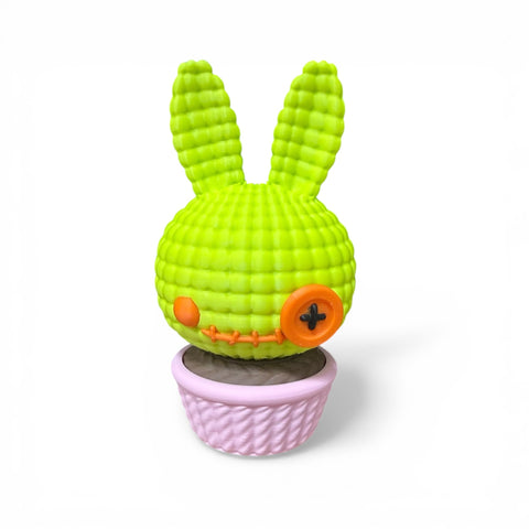 3d voodoo-hase limegrüner gehäkelter hasenkaktus mit orangen knopfund augen in rosa geflochtenem topf