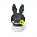 3d voodoo-hase schwarze gestickte hasenfigur mit limegrünem knopfauge und rosa wange im weißen geflochtenen topf