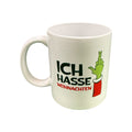Weiße keramik muffel-tasse mit grinch-hand und text ich hasse weihnachten in schwarz und rot