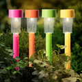 Vier farbenfrohe solar-gartenstecker mit warmweißem licht und durchscheinendem zylindrischem säulenkörper