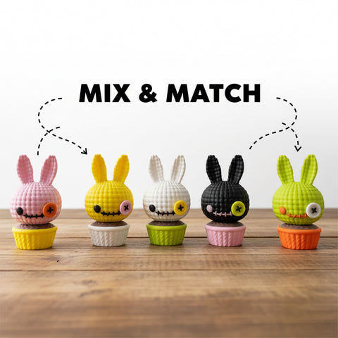 Fünf bunte gehäkelte 3d voodoo-hase figuren mit knopfaugen in passenden cupcake-haltern