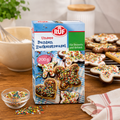 Eine packung ruf bunte zuckerstreusel 200g in blauer und grüner verpackung mit dekorierten keksen