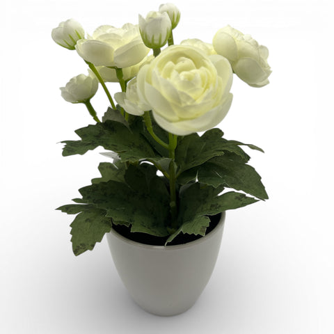 Eine zarte weiße künstliche ranunkel blumenstrauß in einem eleganten matten grauen keramiktopf