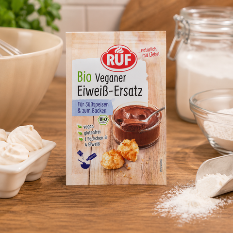 Ruf bio veganer eiweiß-ersatz 20g paket mit schokolade dessert und keksen auf rustikalem holzhintergrund