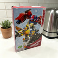 Transformers cookie bites 375g cereal box in red and blue featuring optimus prime bumblebee and other characters in dynamic poses