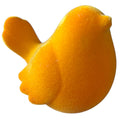 Ein samtig weicher vogel aus plüsch in goldenem gelb als dekoratives objekt