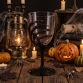 Set aus vier halloween-weingläsern mit farbigen skelett-handmotiven in orange, gelb, schwarz und lila, 18 cm hoch