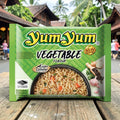 Yumyum gemüse 60g grün verpackte instant nudeln mit gemüsegeschmack und einer schüssel nudeln auf der frontseite