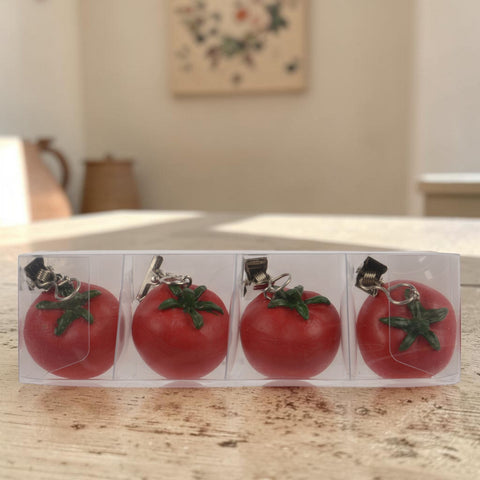 Roter tischdeckengewicht tomate aus metall mit grünem stiel und clipverschluss zum befestigen an taschen oder kleidung