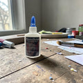 Weiße bastelleim kleberflasche mit blauem deckel und schwarzem etikett für holz filz kork papier im 2er set