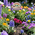 Ein hellgrüner baby yoda gartenstecker grogu in pastellrosa mit rundem design und orangefarbener detailierung
