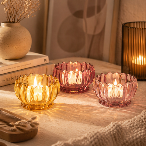 Floraler teelichthalter aus glas mit drei durchscheinenden kerzenhaltern in bernstein und rosa mit blütenrand