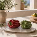 Glänzendes rotes und grünes porzellanpaprika pfeffer sculptureset aus keramik auf weißem marmorplatten display