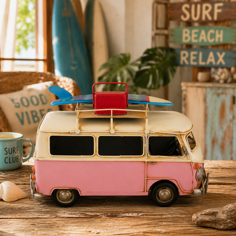 Pastellrosa und cremefarbener vintage-metallcampingbus mit blauem surfbrett auf dem dachträger 29x14x18 cm