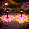 Solar-gartenlampe mit 360° muster zwei solarbetriebene wegleuchten mit schwarzen köpfen und leuchtenden stern- und blütenmotiven
