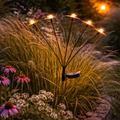 Schwarze metall solar gartenleuchte mit fünf leuchtenden orangefarbenen blumenförmigen lampen solarstecker schmetterling