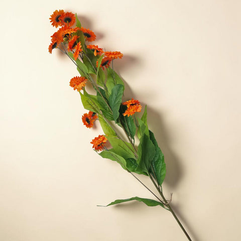 Ein lebhaft orangefarbener künstlicher kamillenbund mit üppigen grünen blättern 102x30x25cm