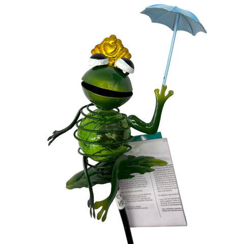 Grüner glasfrosch-gartenstecker mit goldkrone und blauem sonnenschirm aus solar tiermuster-design