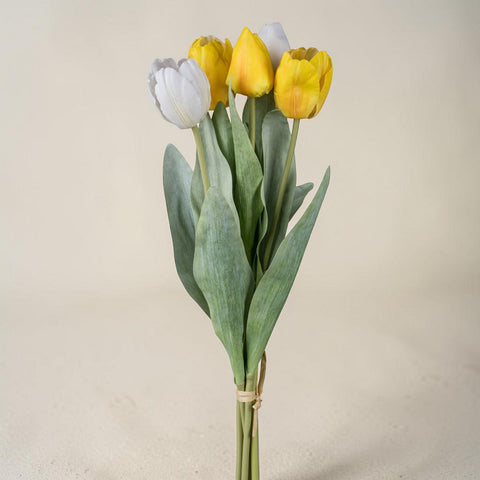 Ein tulpenbund mit 5 künstlichen blüten in leuchtendem gelb und zartem weiß mit realistischen grünen blättern und naturbaumnwollband