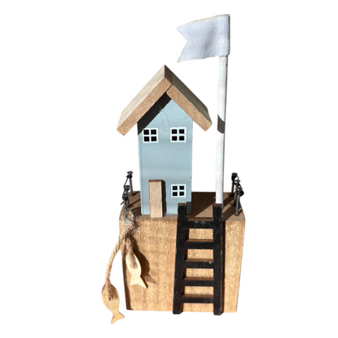 Holz figur häuschen mit hellblauem holzhaus, weißen fensterrahmen, dach in naturholz und rustikalem sockel