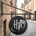 Schwarzes rundes metall türschild harry potter mit silbernem logo und fliegender eule design