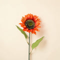 Vibrante orange künstliche sonnenblume 70cm mit detaillierter dunkelgrüner mitte und zwei glänzenden grünen blättern
