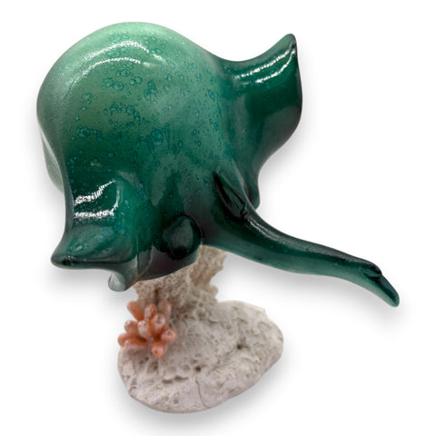 Glänzende teal keramische rochenfigur mit gesprenkelter glasur auf texturierter korallen und felsenbasis