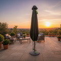 Schwarze sonnenschirmhülle 175cm mit grünem reißverschluss und rand stehend auf terrasse bei sonnenuntergang