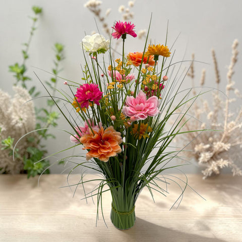 Ein frühlingsgras 70cm künstlicher blumenstrauß mit pinken orange weißen blüten in klarem glasvase