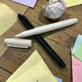 Weißer marker mit feiner spitze und glänzendem finish neben kuppe auf holzoberfläche in stifte marker schwarz und weiß 2er set