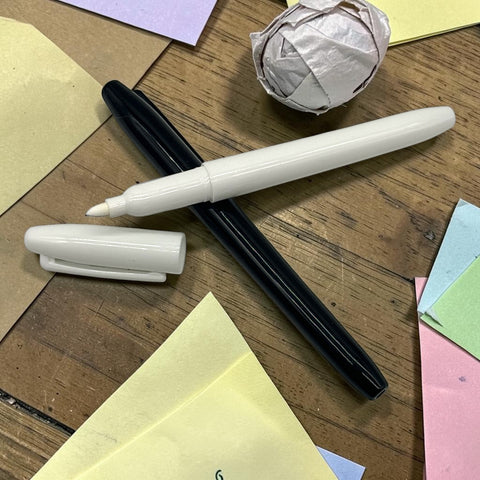 Weißer marker mit feiner spitze und glänzendem finish neben kuppe auf holzoberfläche in stifte marker schwarz und weiß 2er set