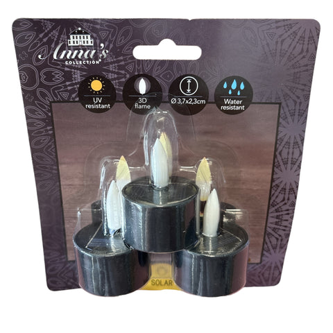 Schwarze solarbetriebene led teelichter mit weißen flammentipps im 3er set auf dekorativer karte verpackt