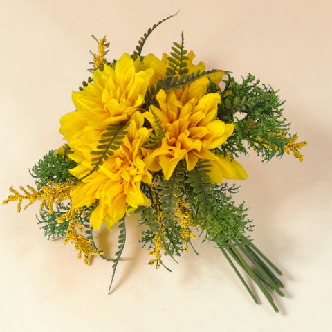 Ein lebhafter gelber künstlicher dahlienbund 30cm mit grünen farnen und goldenen zierblumen