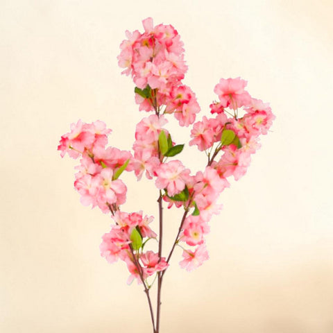 Kirschblütenzweig pink mit zarten rosa künstlichen blüten und kleinen grünen blättern aus kunststoff