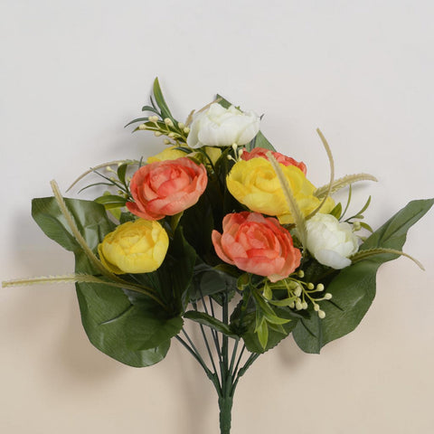 Ein strauß ranukel aus lebhaften künstlichen pfirsich-, gelb- und weißen rosen mit glänzenden grünen blättern