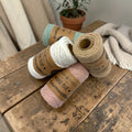 Drei aufgerollte spulen baumwollband macramekord in mint, weiß und rosa mit baumwollband etiketten