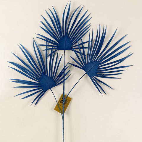 Kunstzweig mit drei blauen künstlichen palmwedeln auf einem stiel aus kunststoff